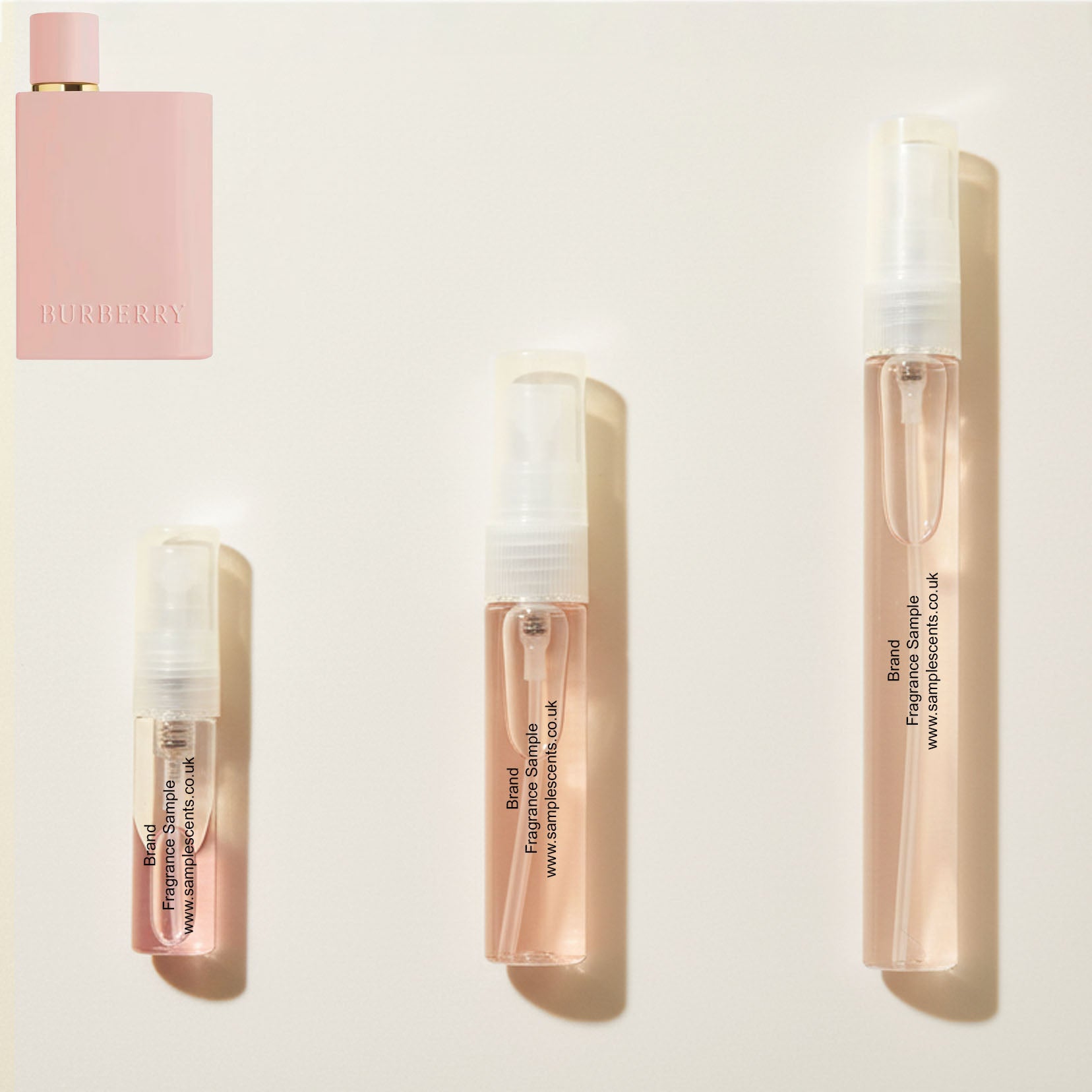 Perfume sample atomisers shown for size reference, hand-decanted from Burberry Her Parfum bottle.