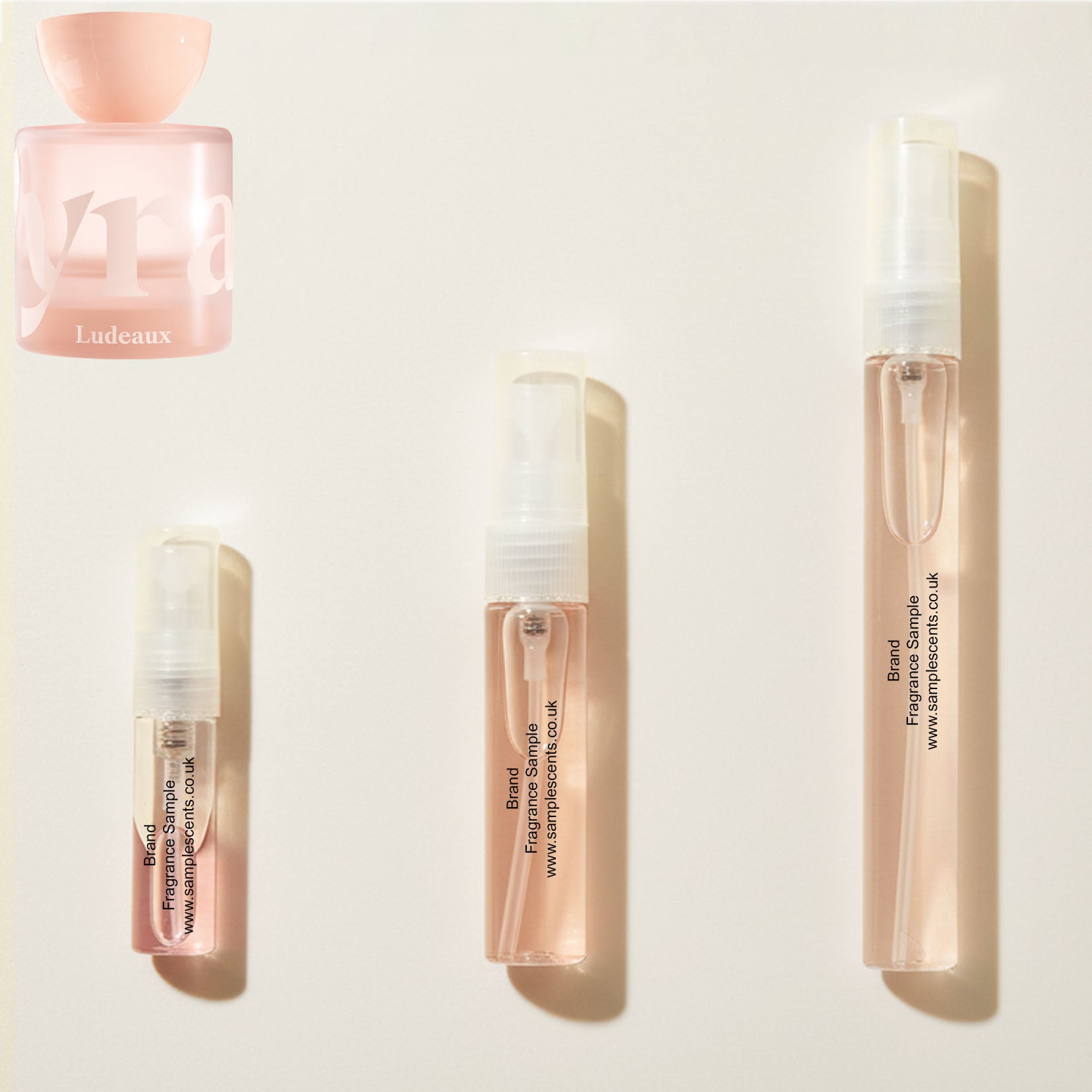 Perfume sample atomisers shown for size reference, hand-decanted from Vyrao Ludeaux bottle.