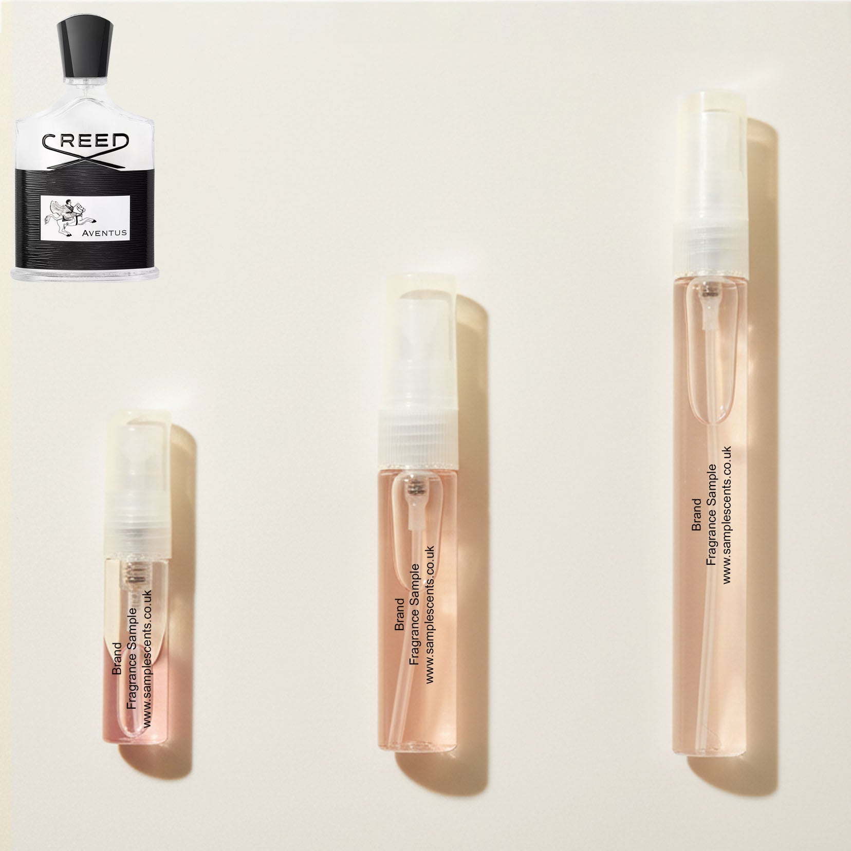 Perfume sample atomisers shown for size reference, hand-decanted from Creed Aventus bottle.